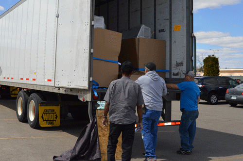 Three men unloading a dry van trailer